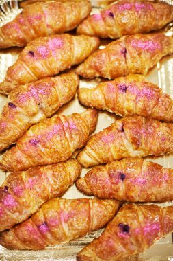 Bir avuç pudralı kruvasan yaldızlı tepside yatıyor. Yakın çekim.