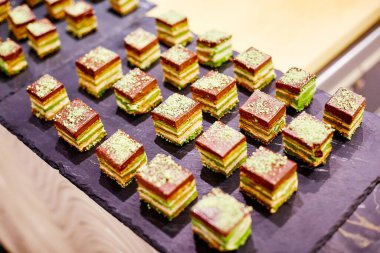 Kare şeklinde kek tepsilerde ziyafet masasında yatıyor.