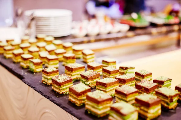 Quadratische Kuchenstücke Liegen Auf Tabletts Auf Einem Banketttisch — Stockfoto