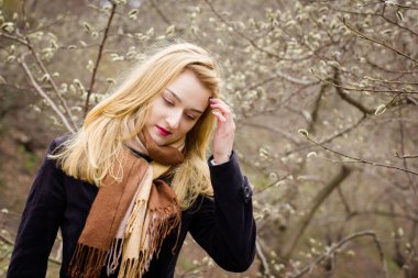 Genç güzel kız bahar bahçesinde yürüyor.