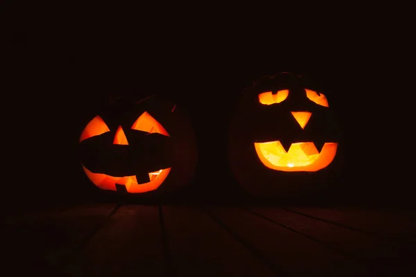 Halloween pumpkin lanterns with evil faces in the dark with light at a halloween festival