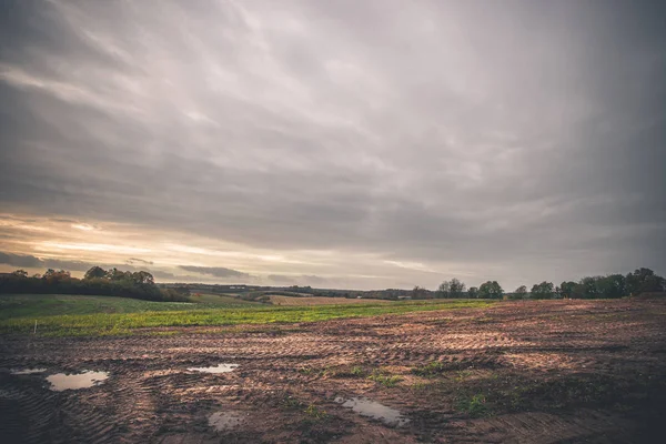 Paisaje con huellas de ruedas en un campo fangoso —  Fotos de Stock