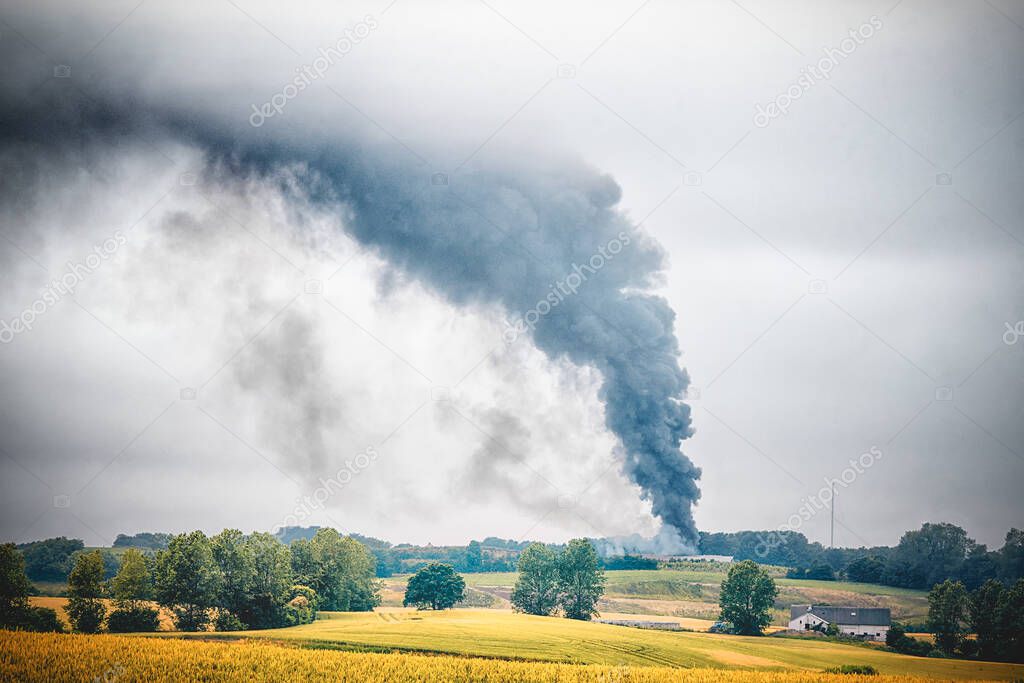 Black smoke from a fire in a rural countryside