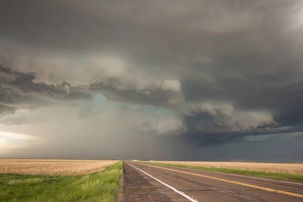 A powerful supercell thunderstorm looms over the highway. — Stock Photo, Image
