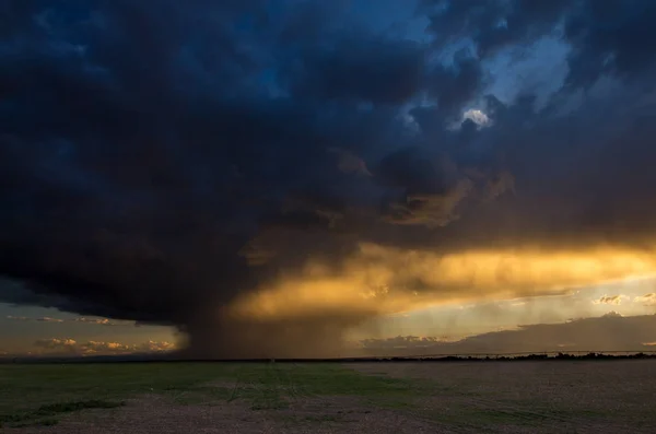 Licht van de zonsondergang verlicht vallende regen in de buurt van de bergen. — Stockfoto