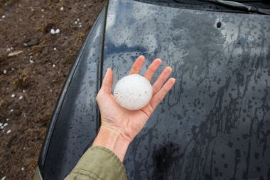 Bir supercell fırtına tarafından bırakılan bir boyutlu beyzbol hailstone tutan el.