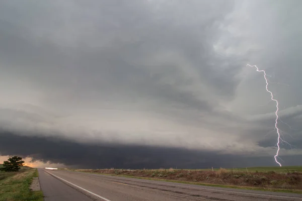 A lightning bolt arcs out of a supercell thunderstorm.