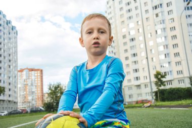 topu ile oturan çocuk