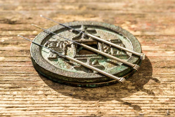 Acupuncture needles on Chinese coin — Stock Photo, Image