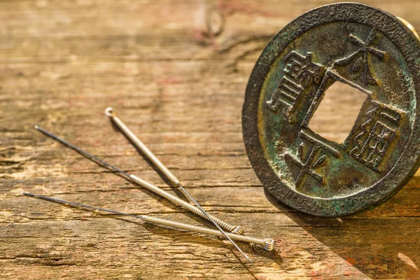 Akupunkturnadeln mit antiken chinesischen Münzen — Stockfoto