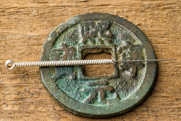 Acupuncture needle on chinese coin — Stock Photo, Image
