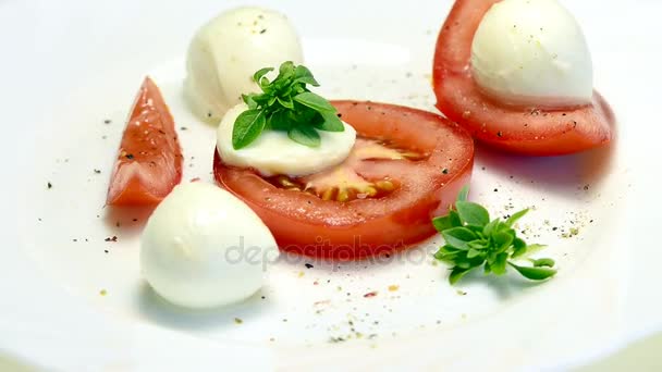 Italiaans voorgerecht tomaten met mozarella en basilicum op een beurt tafel — Stockvideo