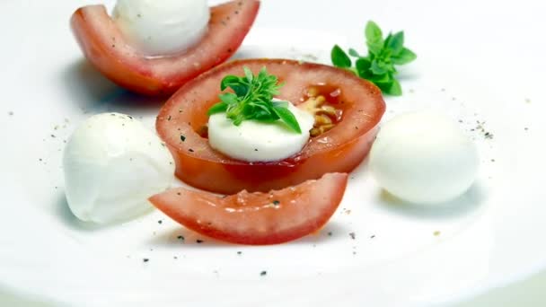 Tomates italiennes en entrée avec mozarella et basilic sur une table tournante — Video