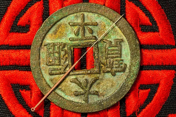 Acupuncture needle on Chinese coin and symbol for immortality — Stock Photo, Image