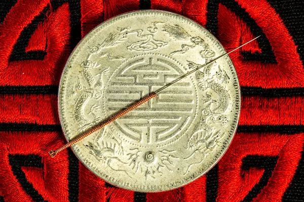 Agulha de acupuntura na moeda chinesa e símbolo de imortalidade — Fotografia de Stock