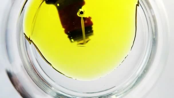 Aceite de oliva corriendo en un recipiente de vidrio — Vídeo de stock