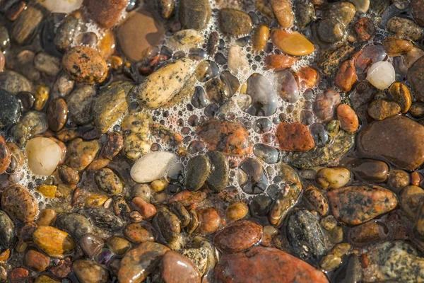 Guijarros en el agua del oleaje del mar Báltico — Foto de Stock