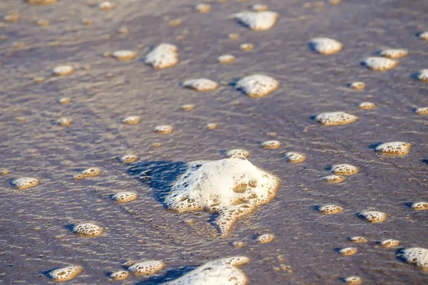 Plage de sable avec galets et spray du surf — Photo