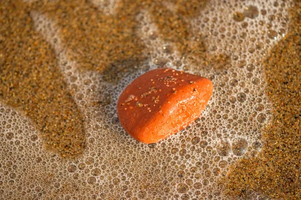 Pebble in the water of the surf — Stock Photo, Image