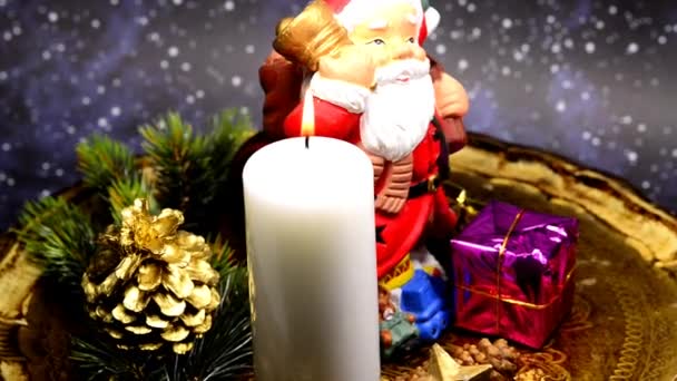 サンタクロースとテーブルの上にろうそくの光とクリスマスの装飾 — ストック動画