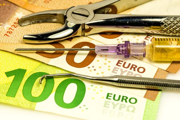 Pinzas dentales e inyección con billetes en euros —  Fotos de Stock