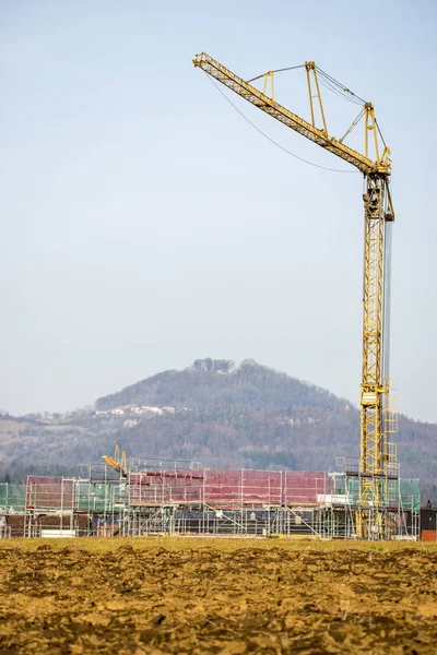 Campo di costruzione in inverno con gru e famosa collina tedesca — Foto Stock