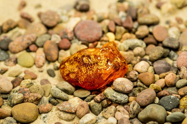 琥珀在沙滩上的卵石 — 图库照片