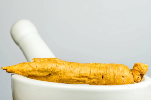 Ginseng root on a mortar — Stock Photo, Image