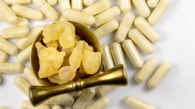 Olibanum, pieces in a mortar and Olibanum capsules