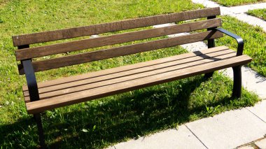 Güneşli ve gölgeli boş park bankı