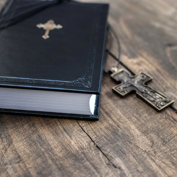 Christian cross necklace next to holy Bible — Stock Photo, Image