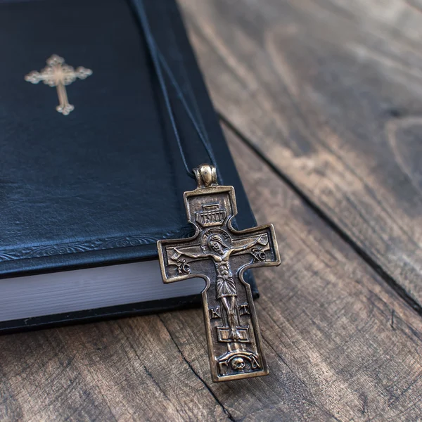 Colar cruz cristã ao lado da Bíblia Sagrada — Fotografia de Stock