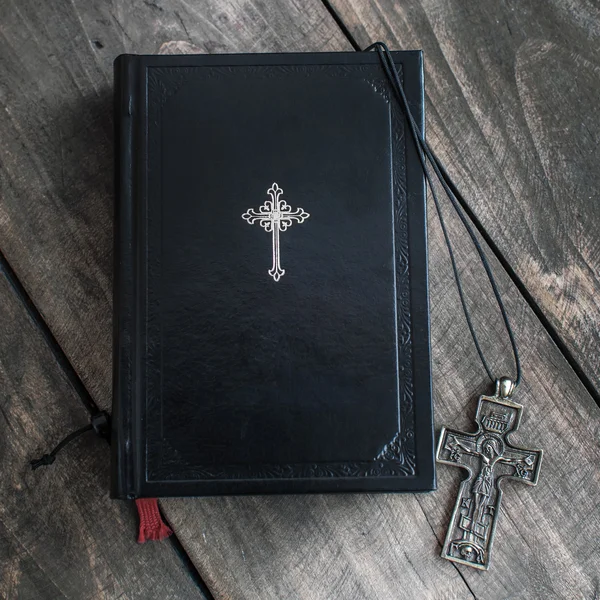 Christian cross necklace next to holy Bible — Stock Photo, Image