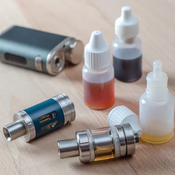 E-cigarettes with lots of different re-fill bottles — Stock Photo, Image