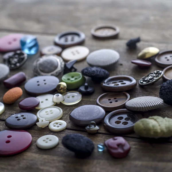 Wiele przycisków vintage na starym drewnianym stole — Zdjęcie stockowe
