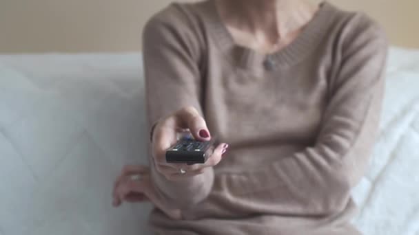 Närbild av en kvinna som håller en fjärrkontroll — Stockvideo