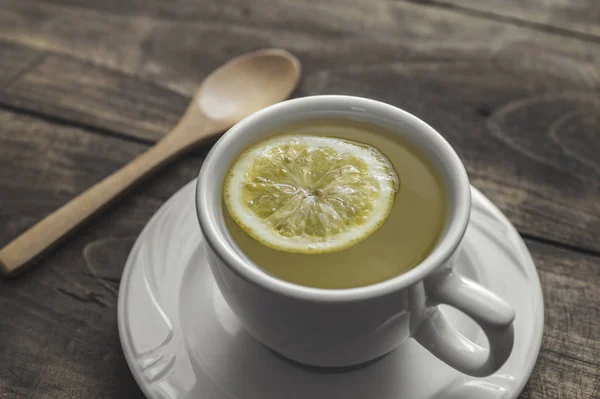 Teetasse mit Zitrone auf Holztisch — Stockfoto