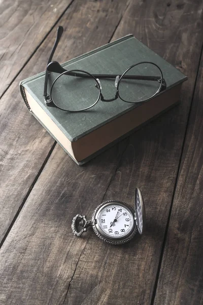 Orologio da tasca antico, occhiali e libro — Foto Stock