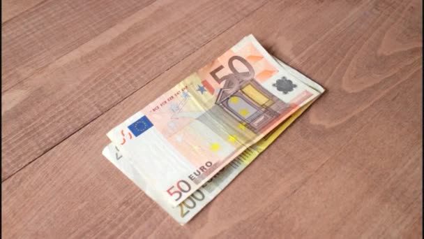 Contando billetes en euros sobre un fondo de madera — Vídeos de Stock