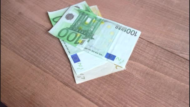 Contando billetes en euros sobre un fondo de madera — Vídeo de stock