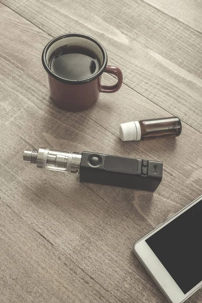 Vaping kümesi, smartphone ve ahşap masa kahve. — Stok fotoğraf