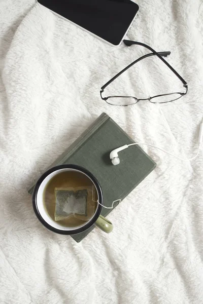 Livre et lunettes sur un lit — Photo