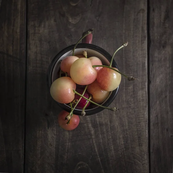 Свежие сорванные вишни на темном деревянном столе — стоковое фото