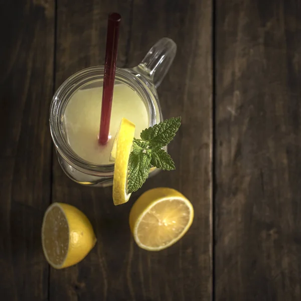 Lemonade glass jar with lemon wedges and straw — Stock Photo, Image