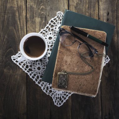 Kahve, defter, gözlük ve eski kolye