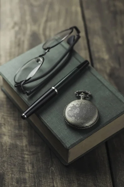Orologio da tasca antico, occhiali e libro — Foto Stock