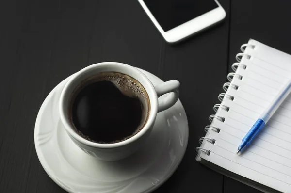 Smartphone met notitieboekje en kopje koffie — Stockfoto