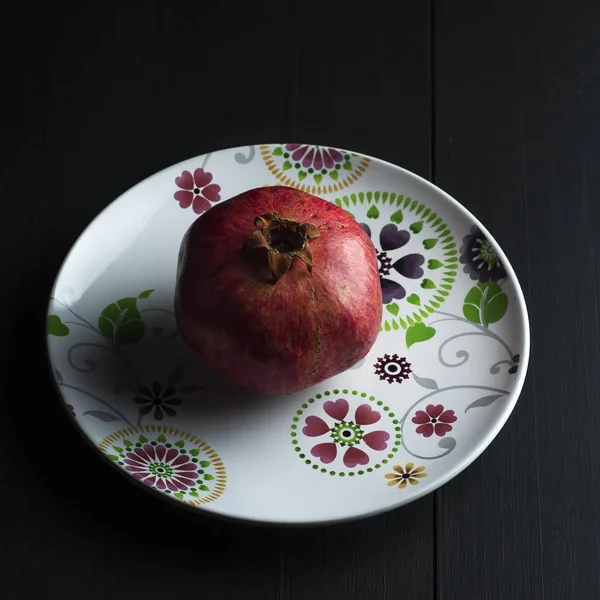 Granatapfel auf weißem Teller — Stockfoto