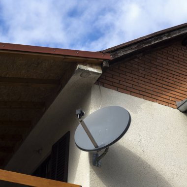 Satellite antenna on a house facade clipart