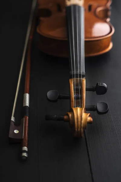 Старая скрипка с бантом на деревянном столе — стоковое фото